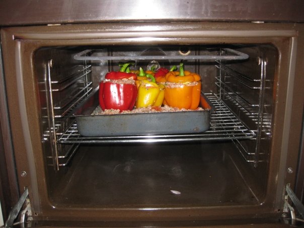 an open oven with lots of colorful peppers in it