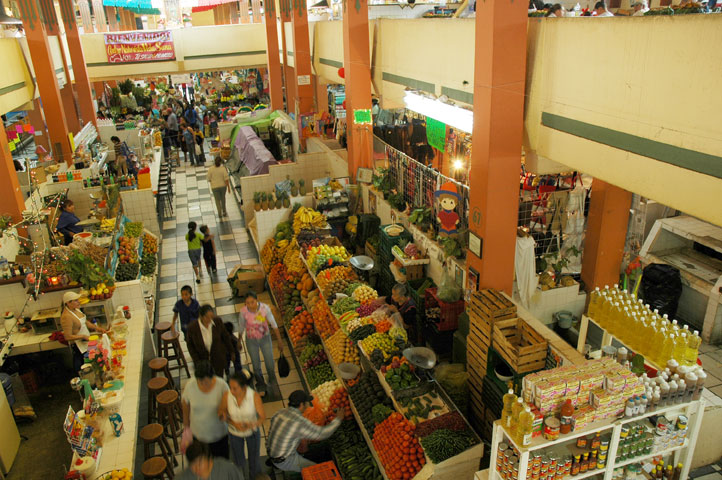 several groups of people in a produce market