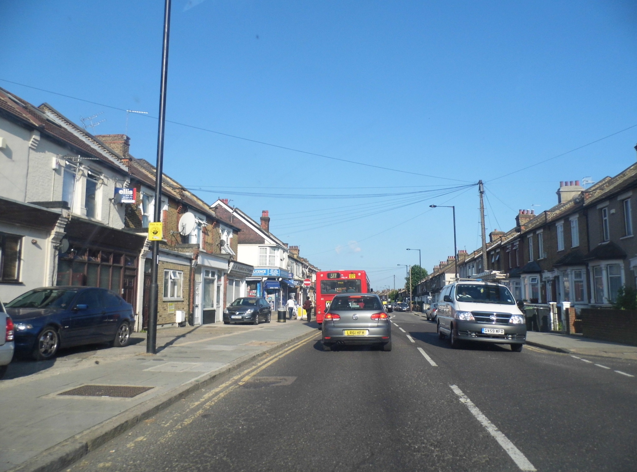 an empty street with a double decker bus driving on the road