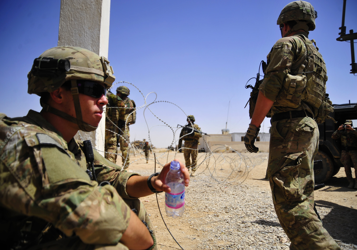 a group of men standing in a desert next to each other