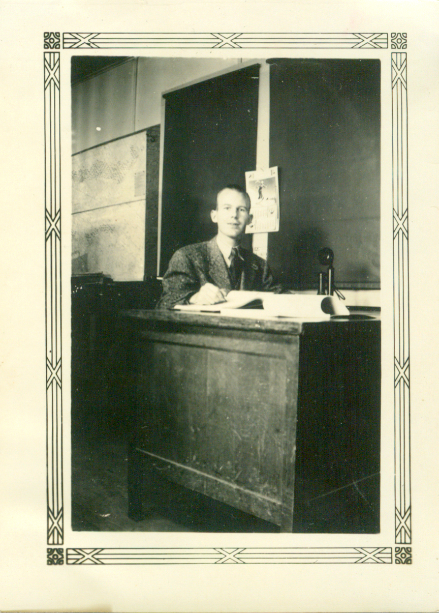 a man sitting at a desk in an office with a poster