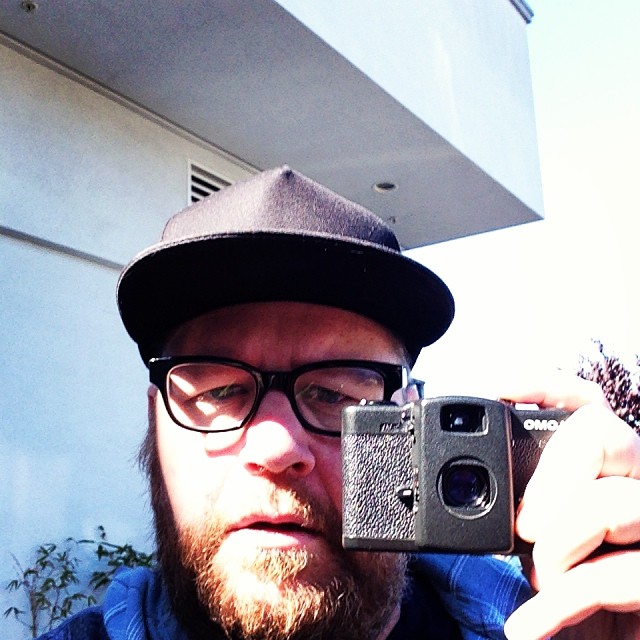 a man with a beard holding a camera