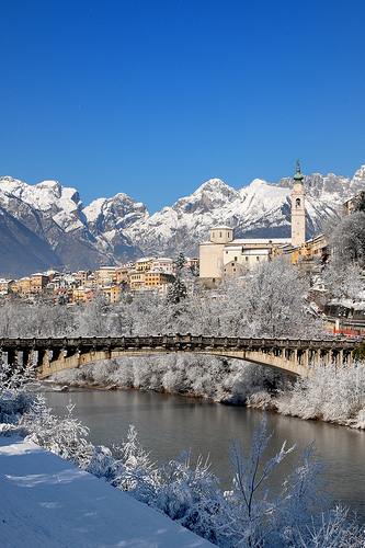 some buildings and mountains are shown along a river