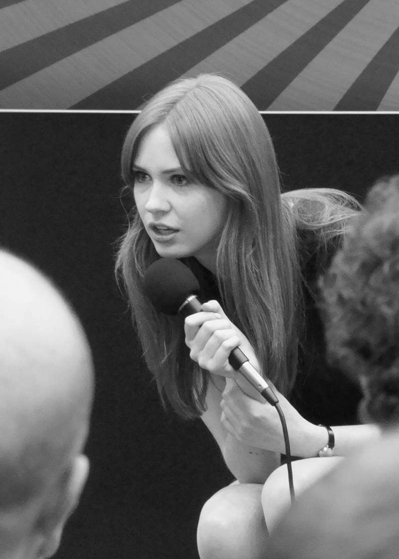 a woman that is sitting down with a microphone