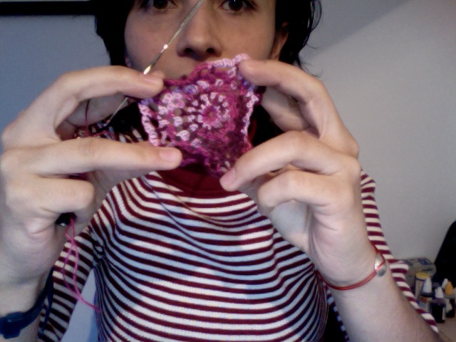 a person is holding a piece of pink yarn