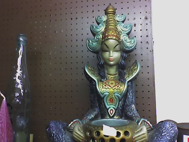 a statue sitting on top of a shelf next to a vase