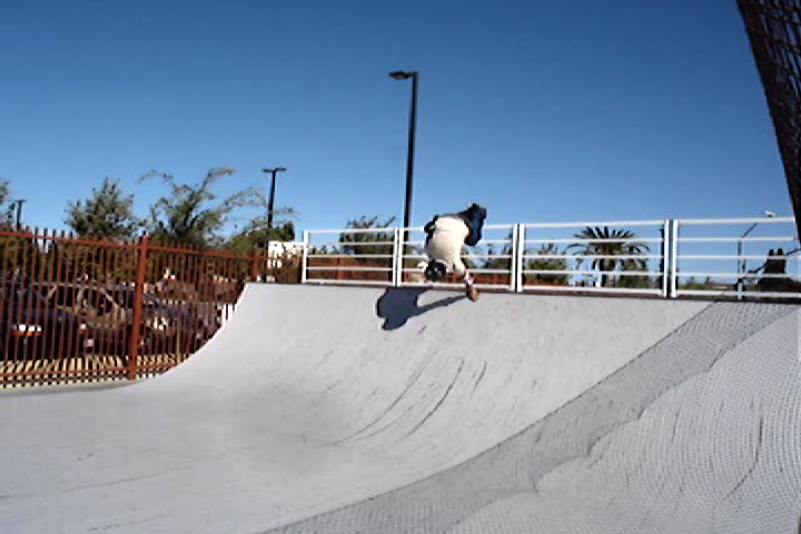 a young skateboarder performing a trick in a skate park