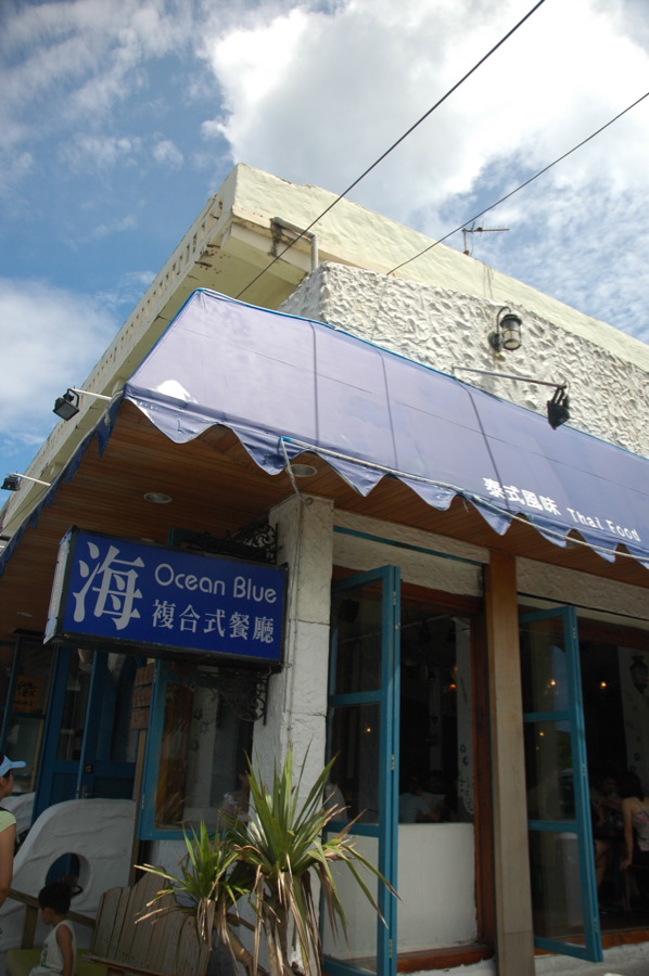 an outside view of a chinese restaurant with blue and white awnings