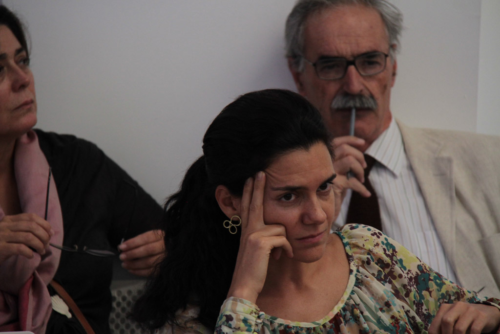 a woman holds her nose while sitting in front of an older man