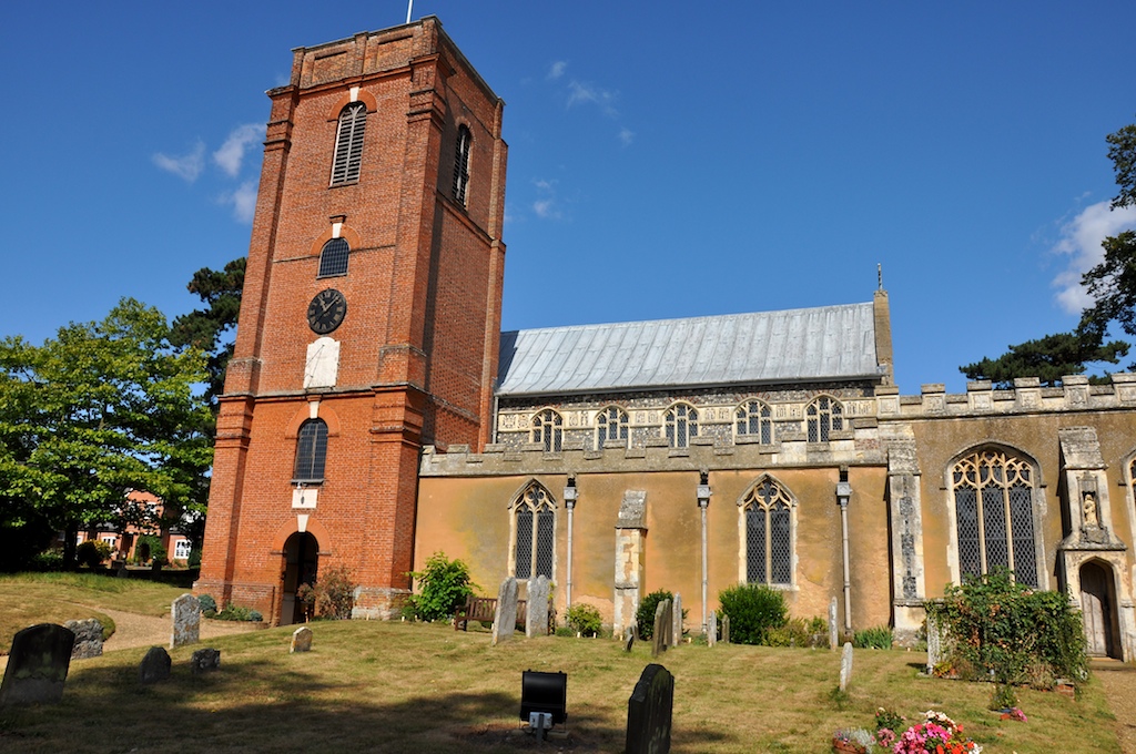 a tall brick building with several windows and a steeple