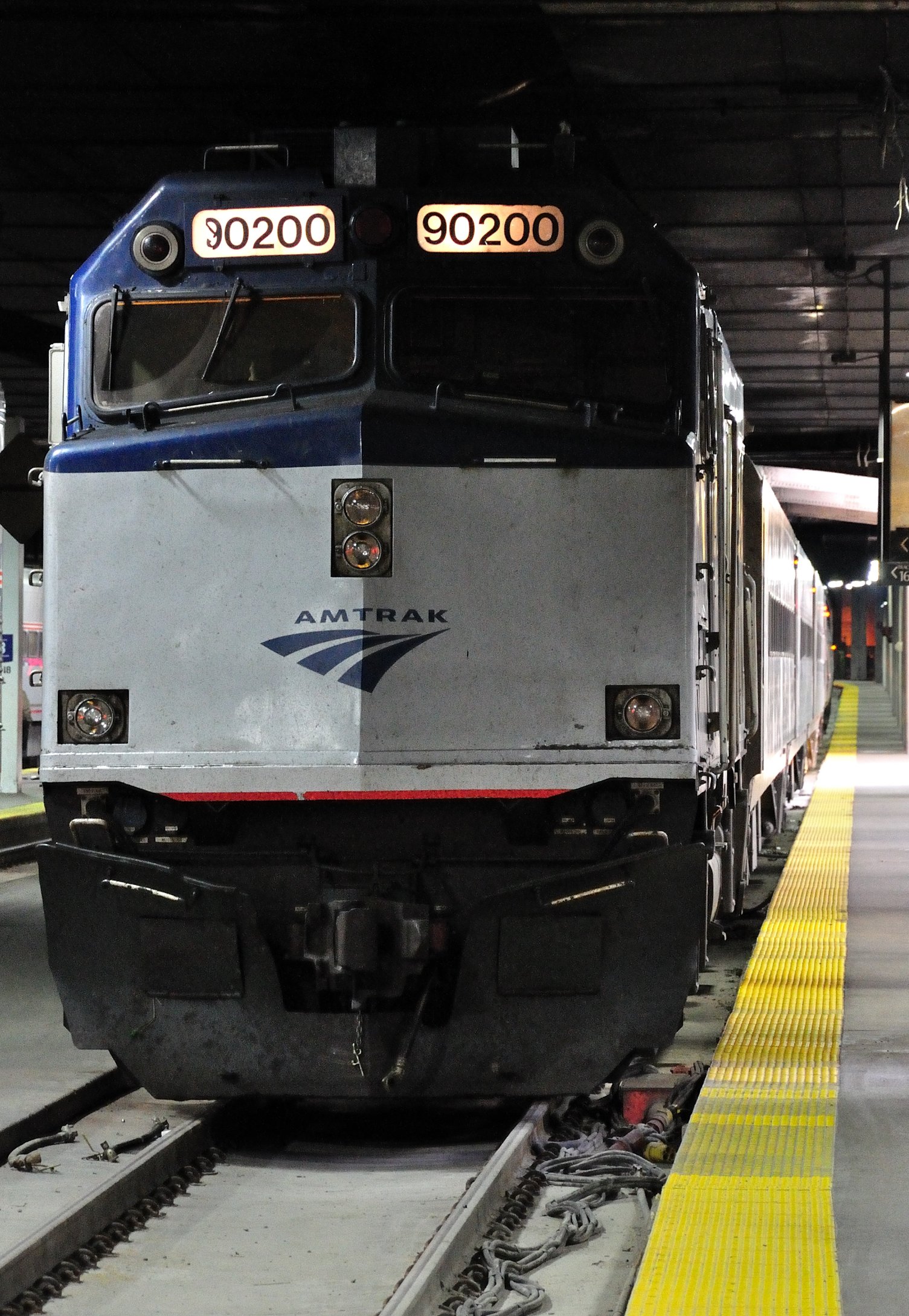 a blue and white train pulling into a station