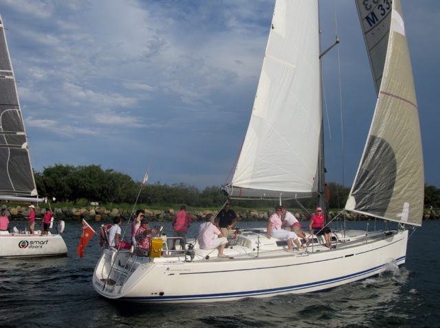 a small white sail boat with several people on it