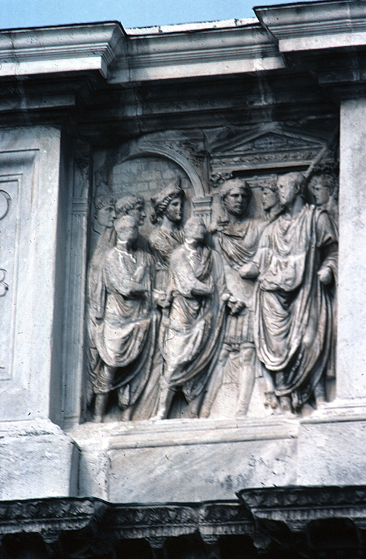 a statue of three men surrounded by women