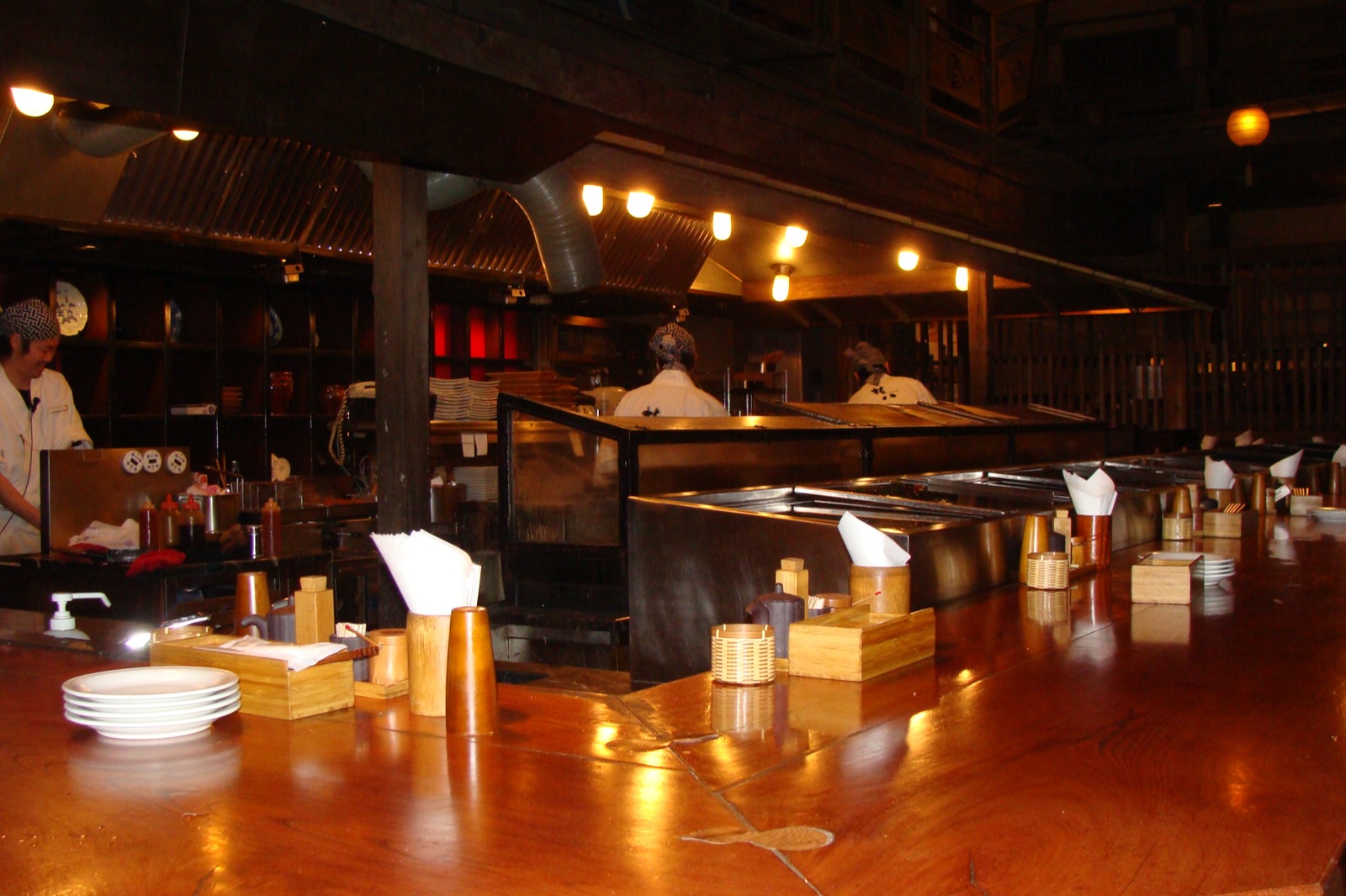 a restaurant with large wooden counter tops and a chef in white uniform