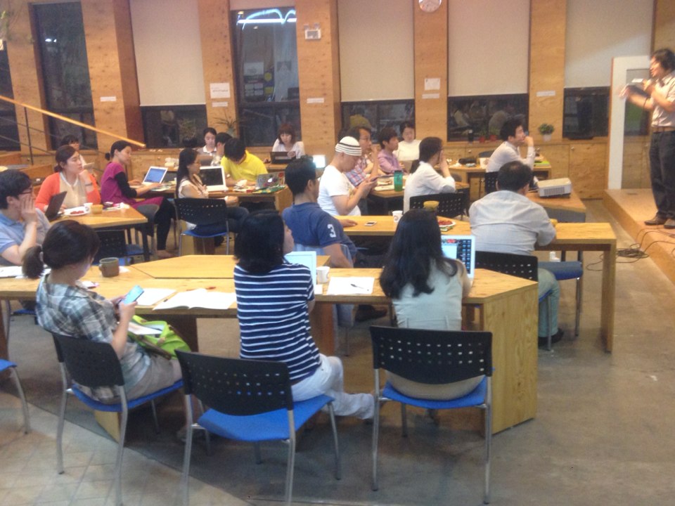 people sitting at tables and discussing in a classroom