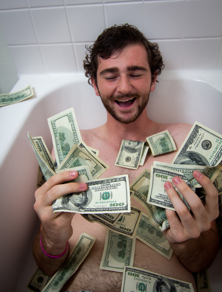 a person in a tub with money all around them