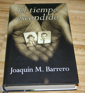 a book on a wooden table with two hands holding pictures
