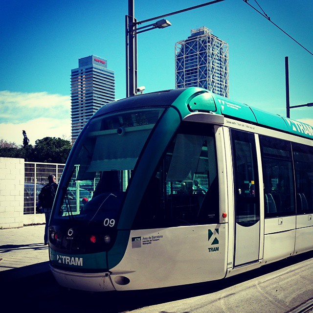 a light rail train traveling past a city