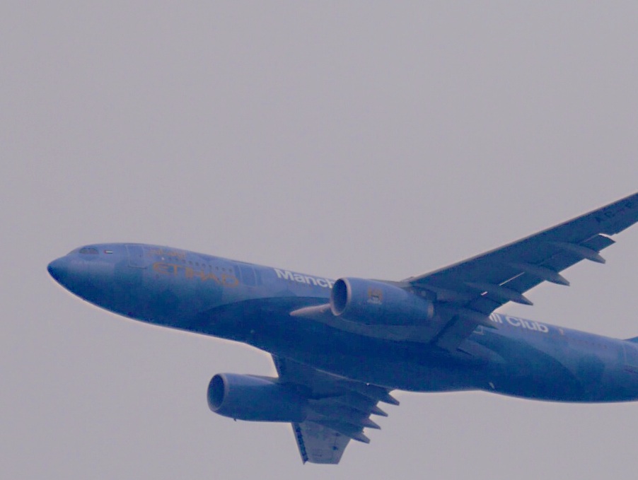 a blue air plane flying in the sky