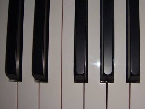 a piano has black keys sitting on top of it