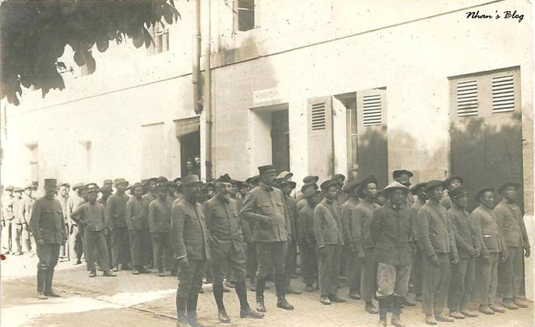 men in old clothing standing in line near the side of a building