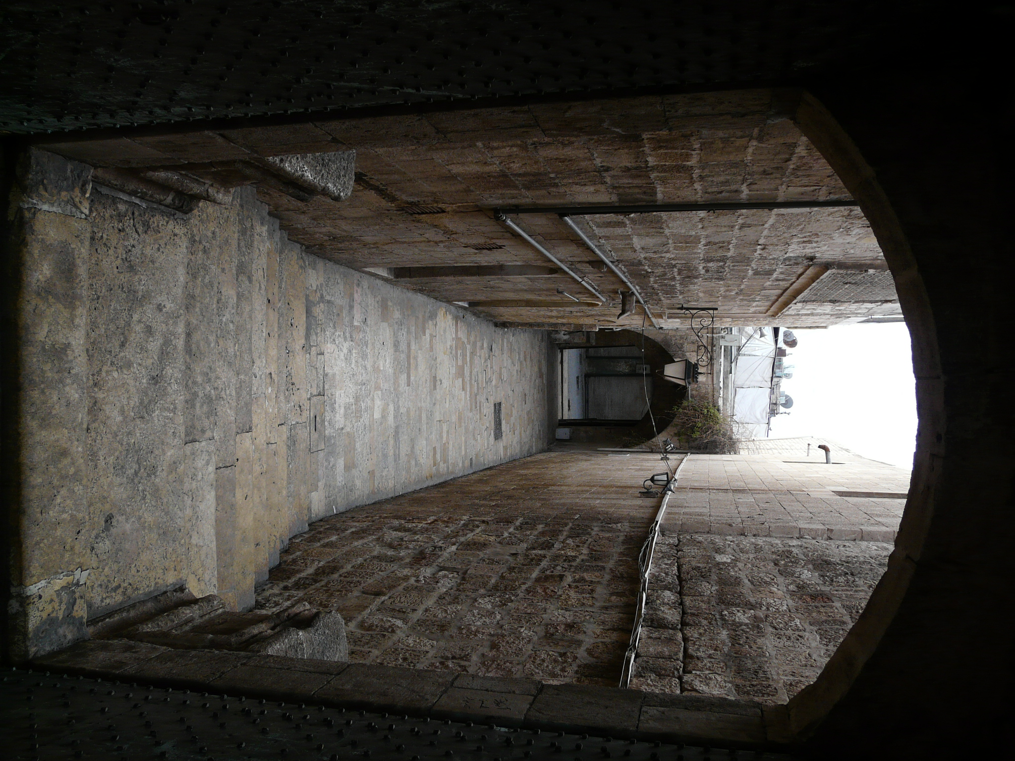 an alley way with a stone wall and steps