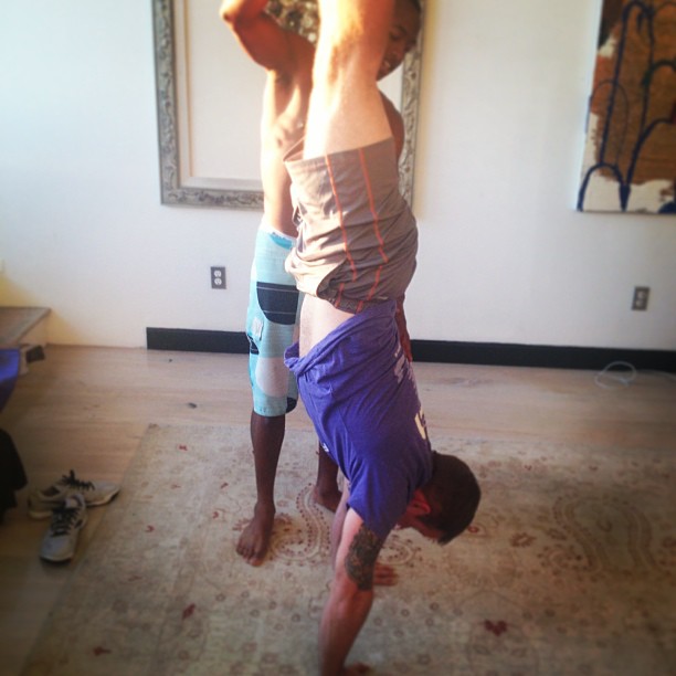 two young men are doing yoga, some standing up on their feet