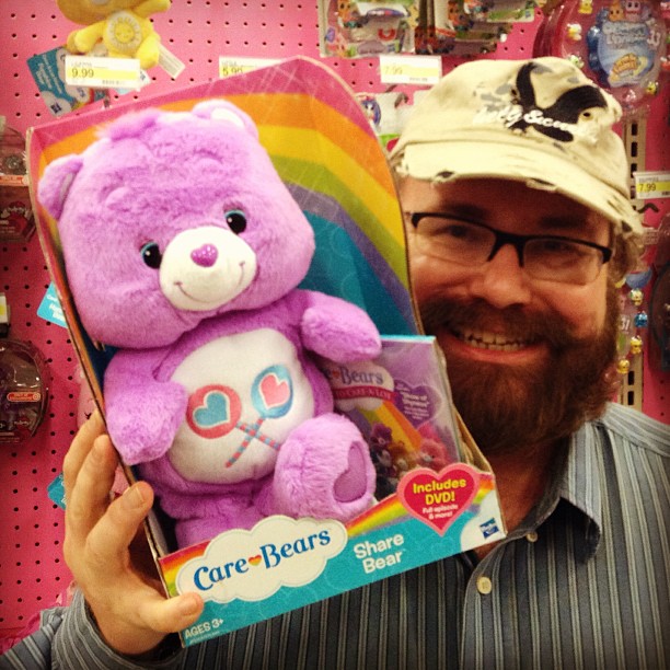 a man holding a purple bear in a store
