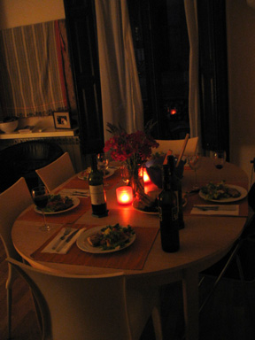 a dinner table with two place settings, and a candle set on it
