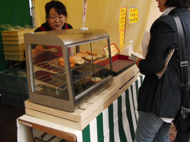 a woman buying a bagel behind a counter