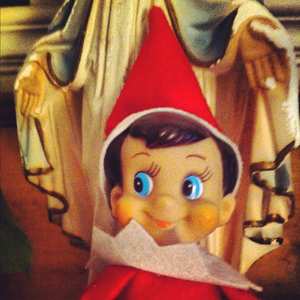 an elf doll with large blue eyes wearing a red and white dress
