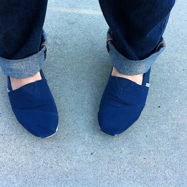 close up po of someone's feet with blue shoes on