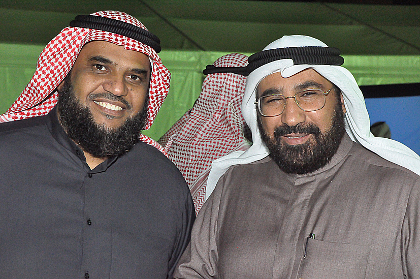 two men wearing suits and hats pose for a picture