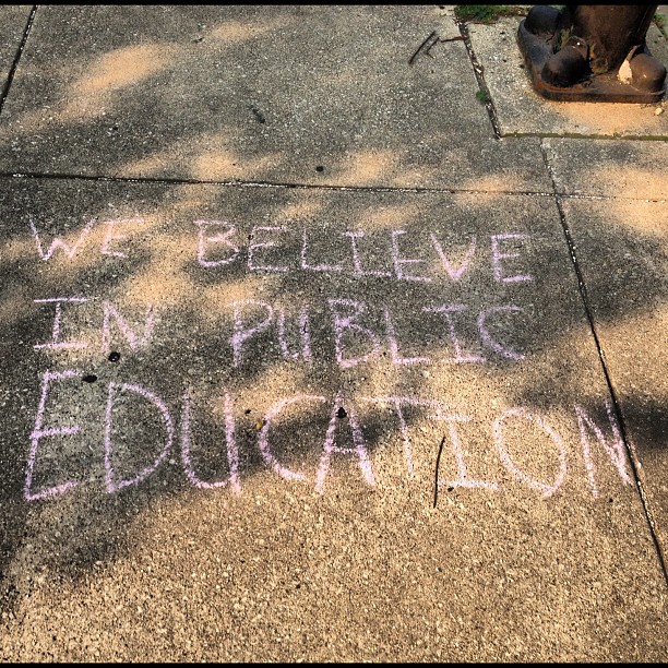 a sidewalk with a chalk message painted on it