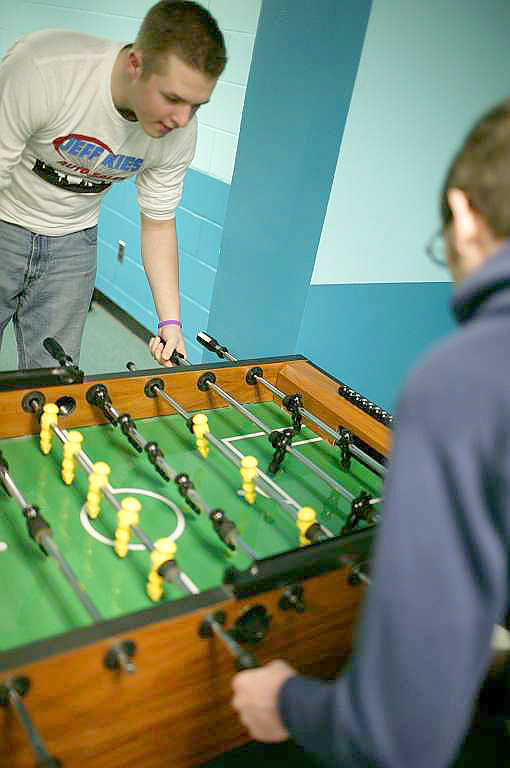 two young men playing foo foo in a locker room