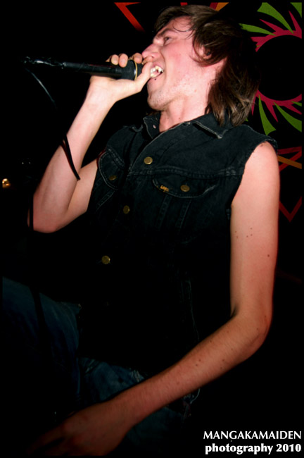 young male with open mouth singing into microphone