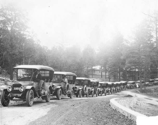 many old trucks are lined up along a road
