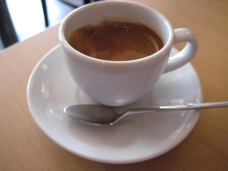 coffee cup and spoon sitting on saucer on table