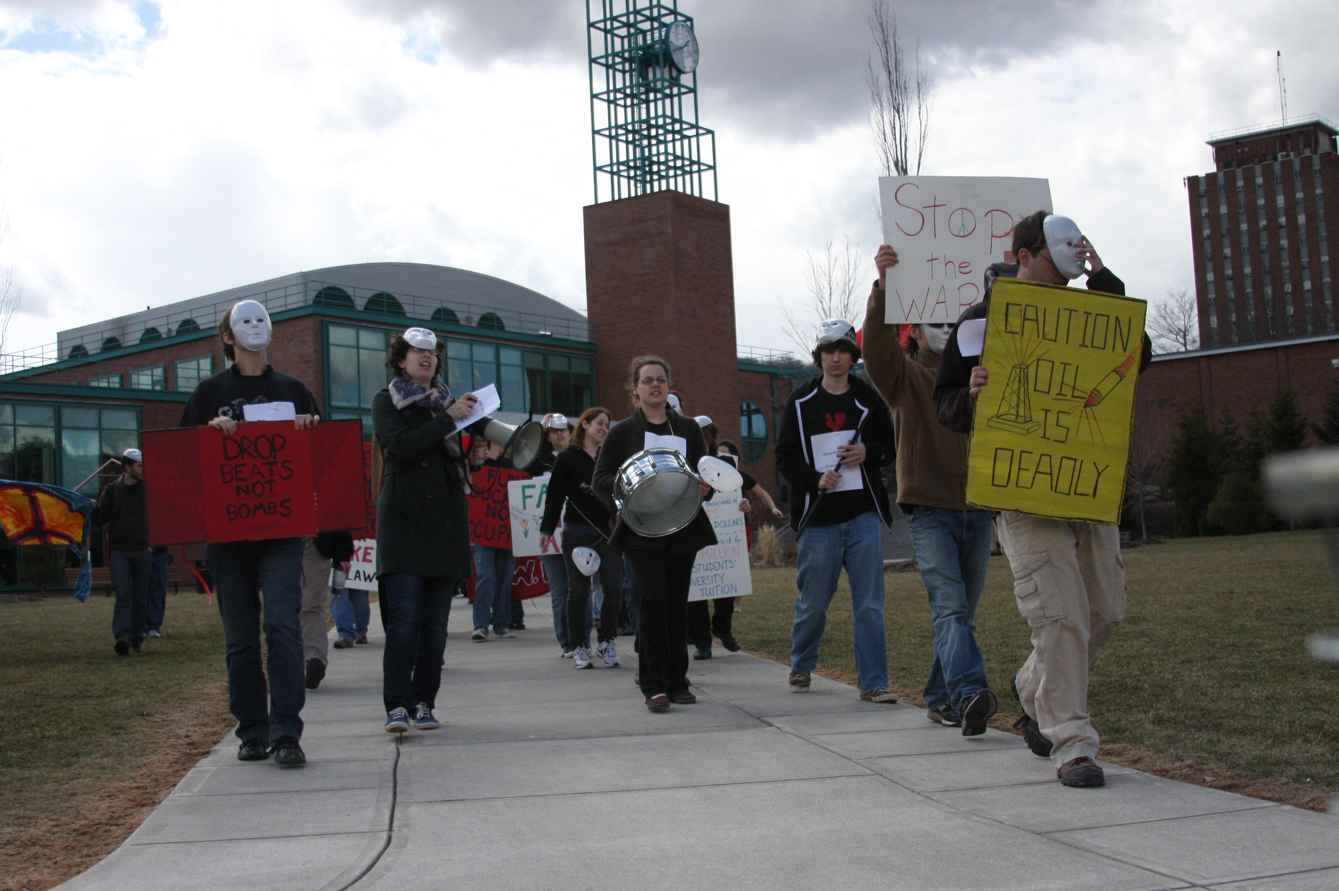 group of men walking down the street holding protest signs