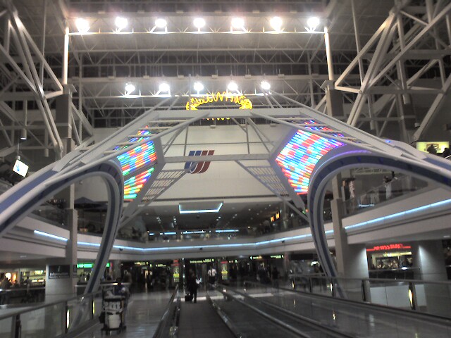 a long walkway in a large building with lots of lights