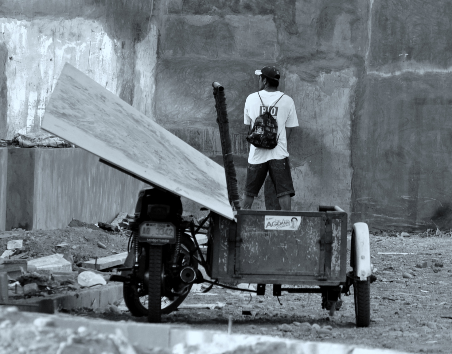a black and white po of a man putting wood on to a cart
