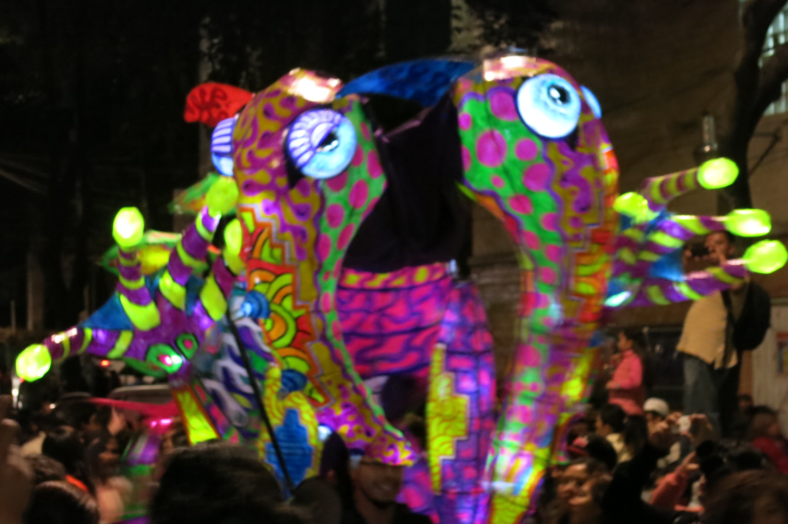 several large decorated animals in a crowded area