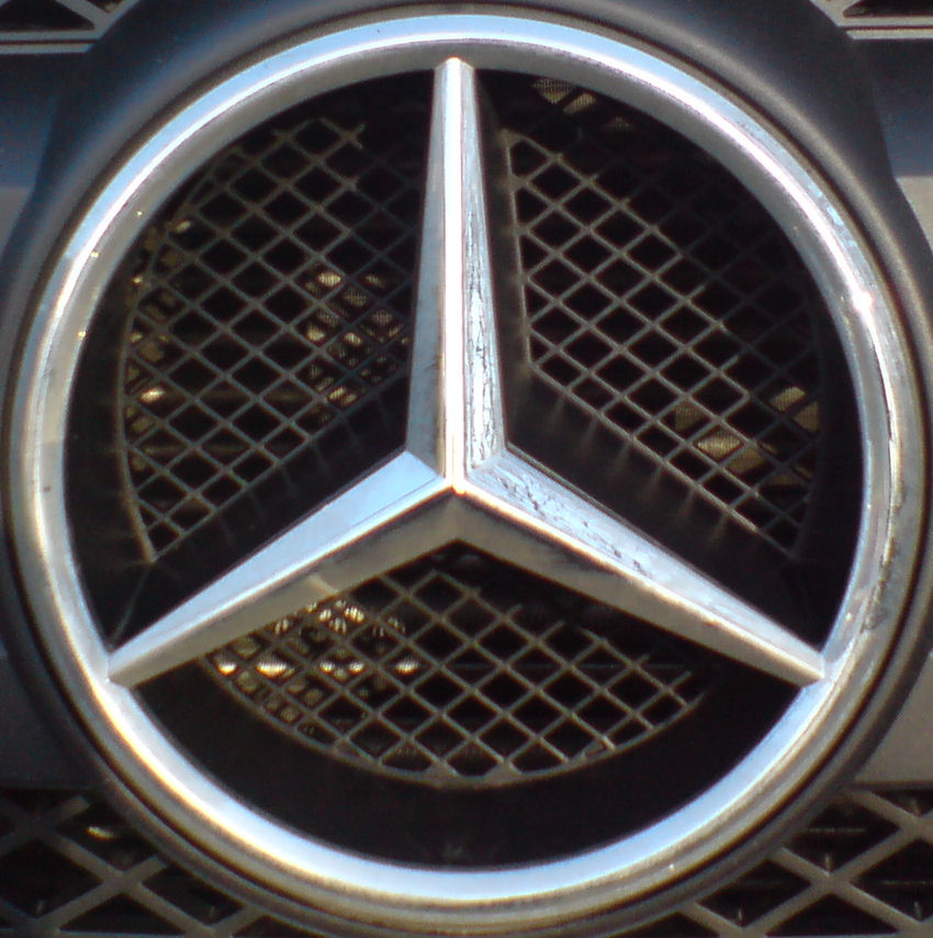 the emblem of a mercedes car on a grill