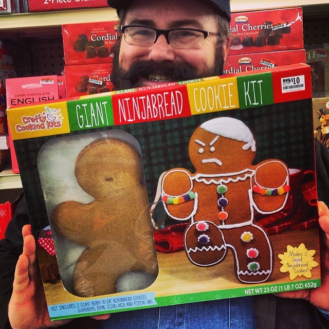 a man holding up a giant paper plate of gingerbread