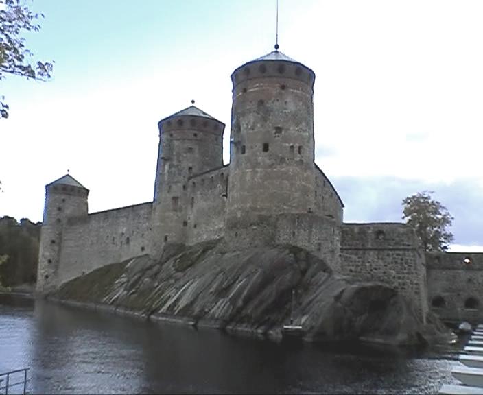 an old castle on a rock by a body of water