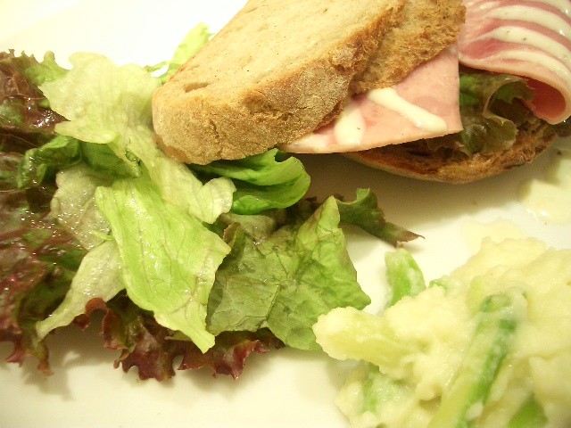 there is a salad and a sandwich on the plate