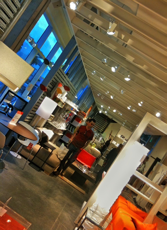 large modern looking retail with light colored furniture and open windows