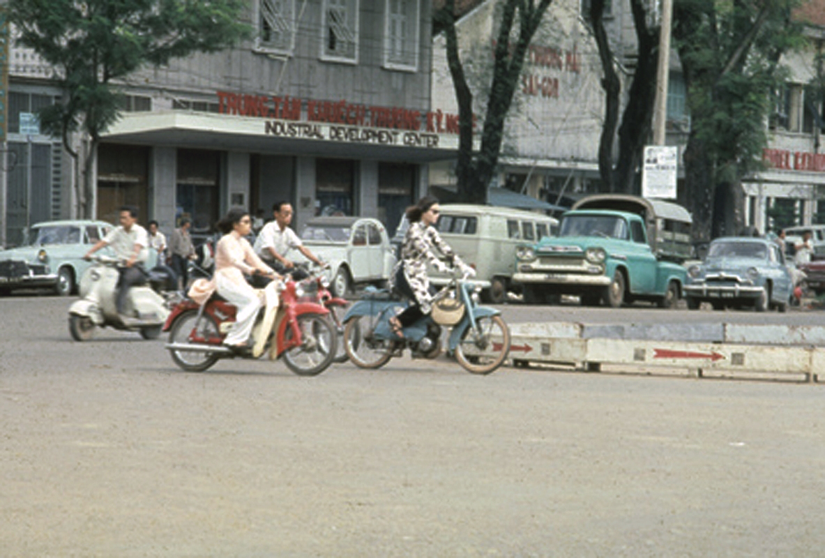 a group of people are riding down the street on motor cycles