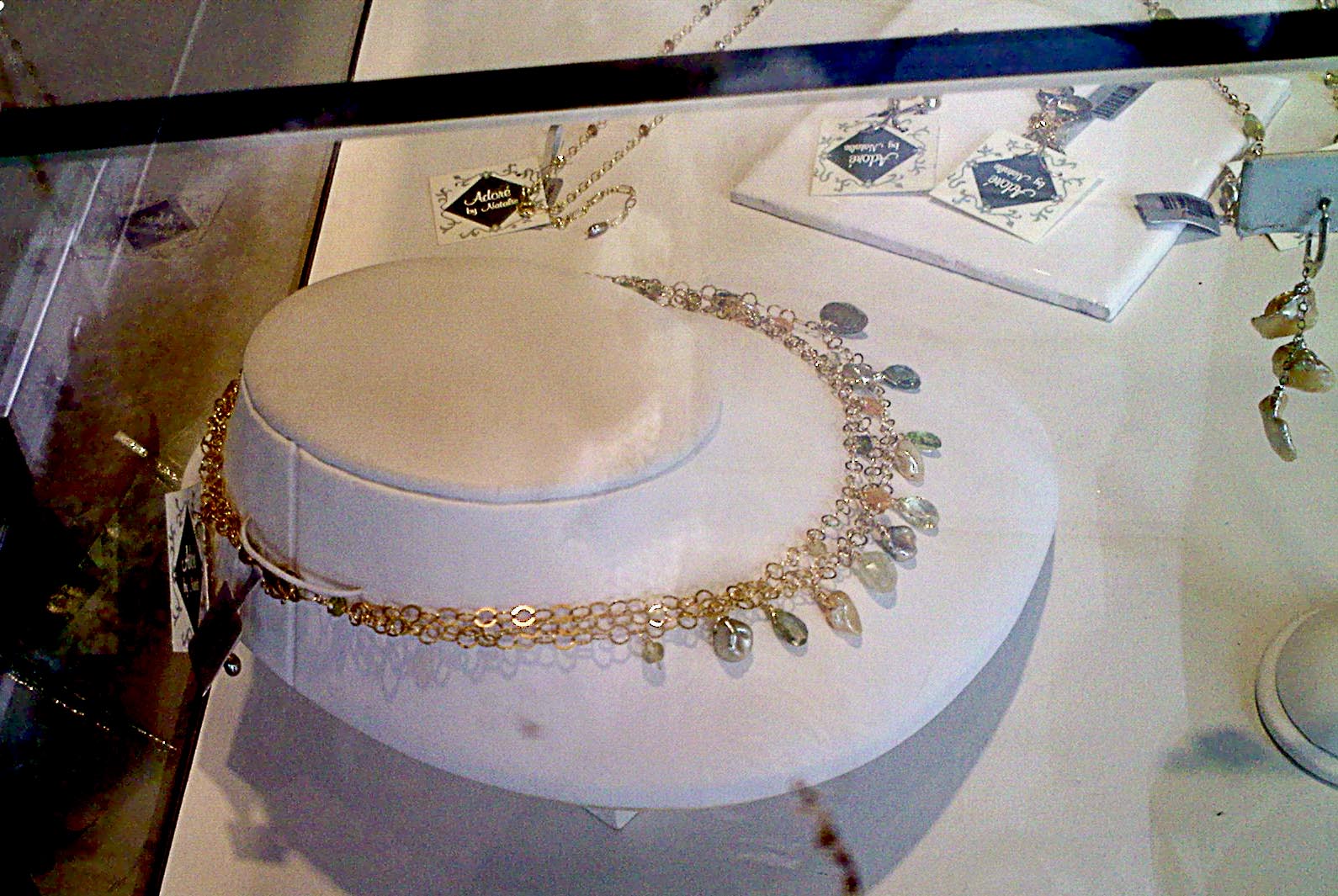 a necklace and celets displayed on display in a glass case