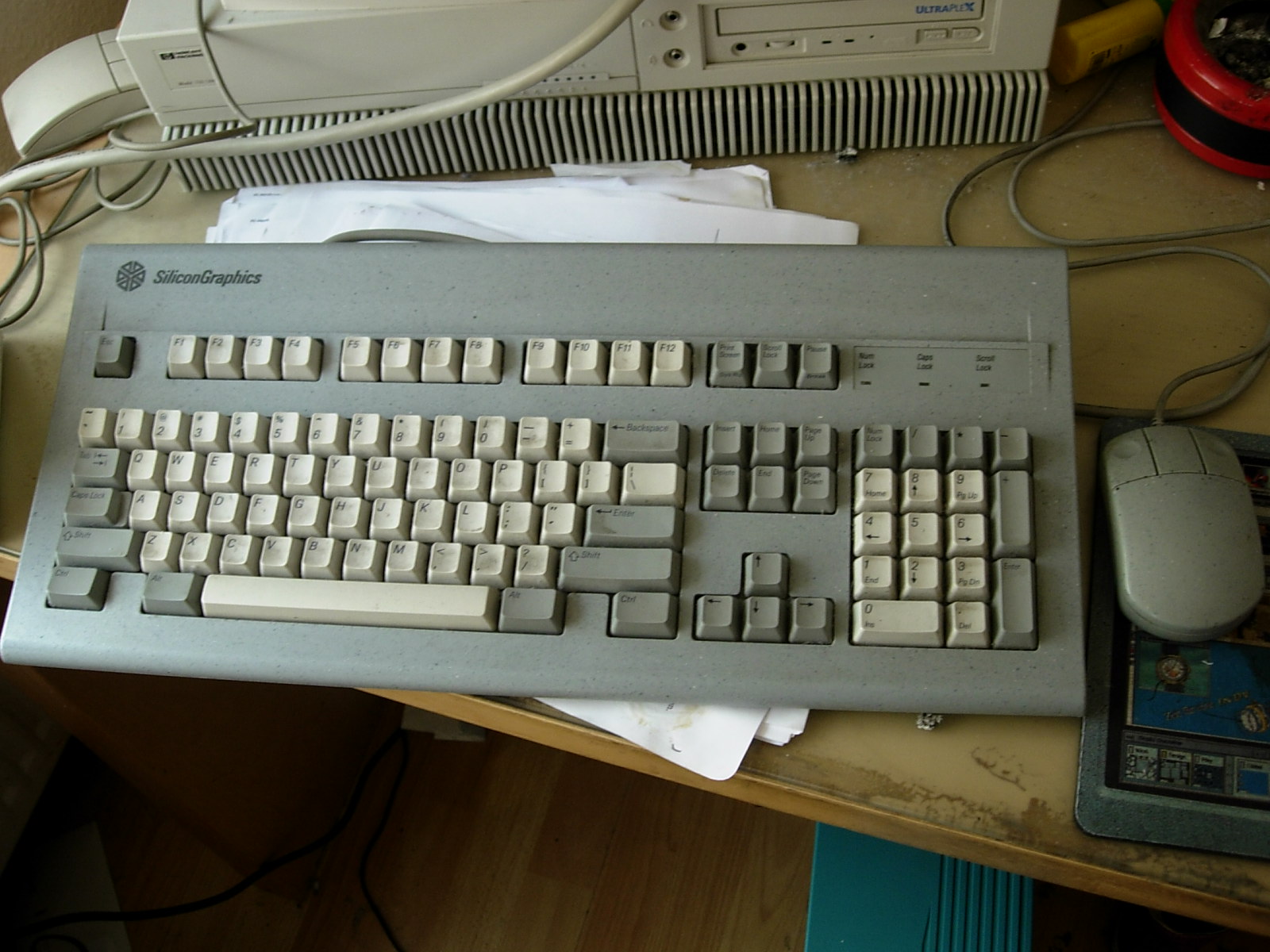 a computer keyboard and mouse sitting next to an older model computer